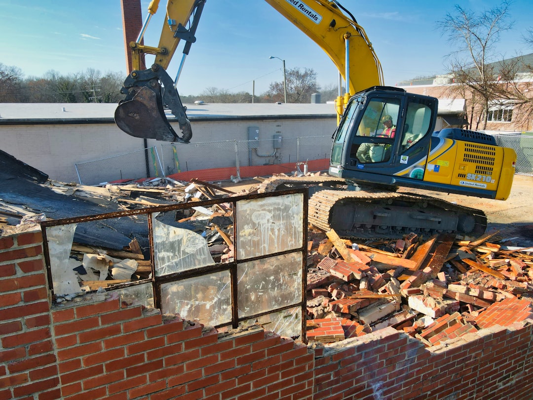 Excavator tearing down a residential structure on a Jackson, Tennessee demolition site